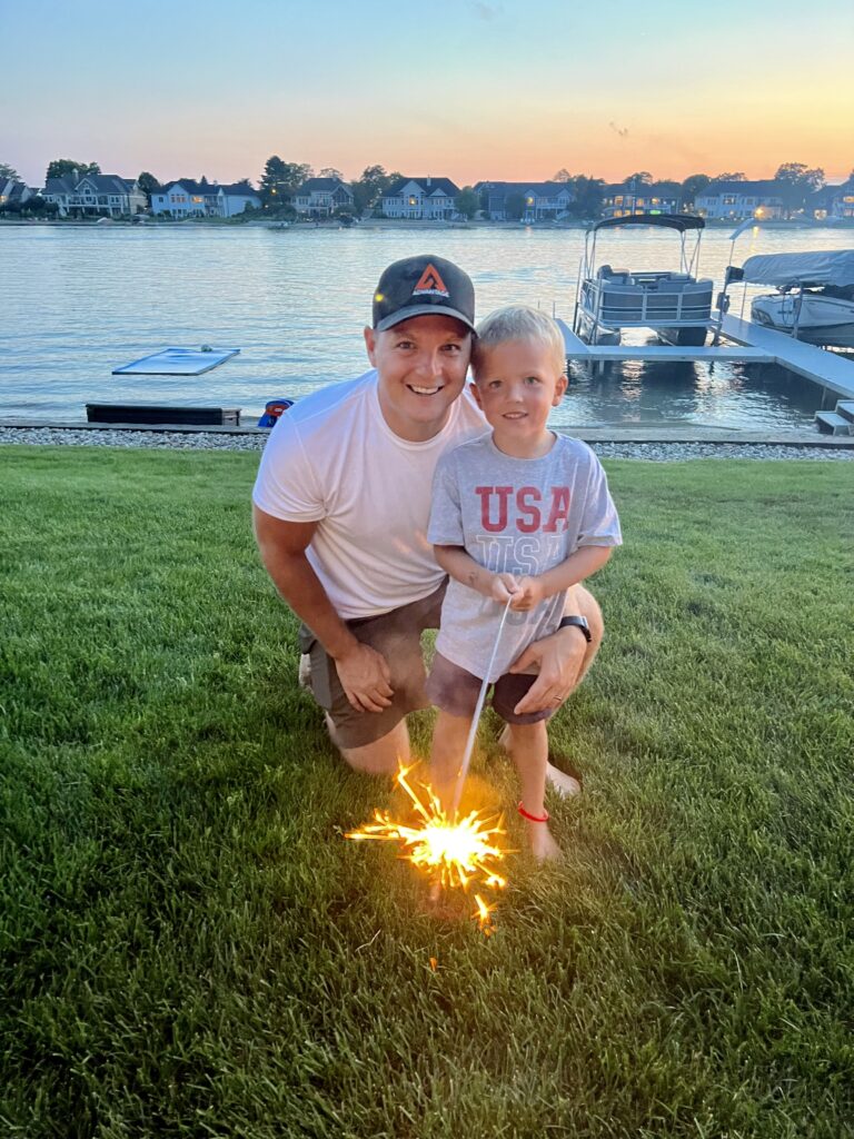 Man and son smiling with a sparkler